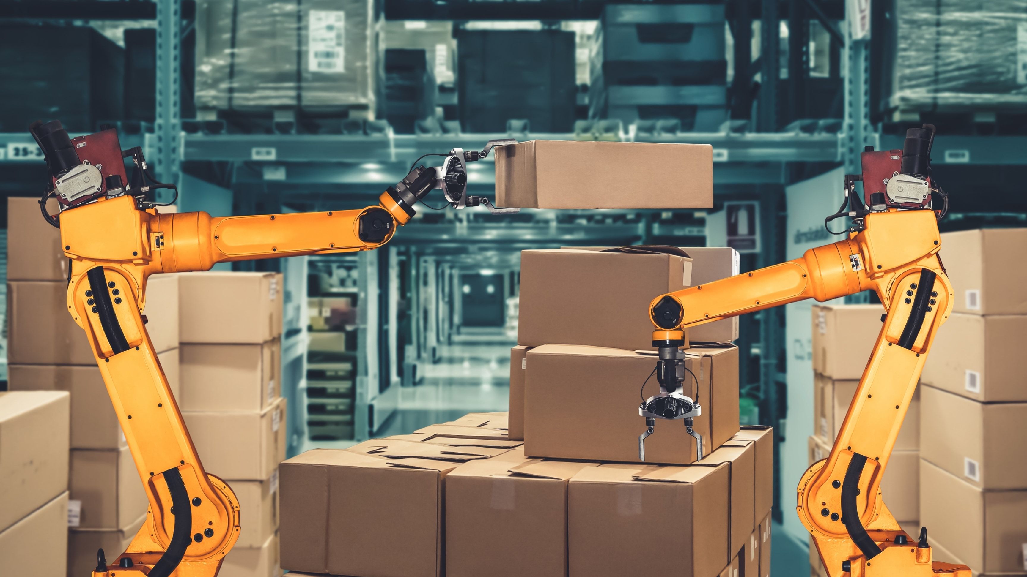 Robots industriales paletizando cajas de cartón en un almacén